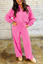 Woman wearing pink solid color collared pullover and central seam pants set with drawstring and pocket.