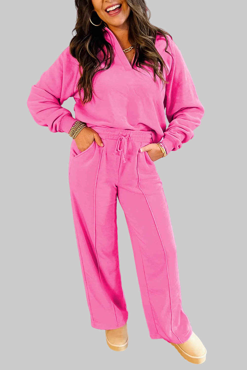 Woman wearing pink solid color collared pullover with drawstring and central seam pants set