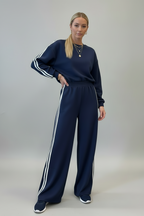Woman wearing dirty blue varsity striped detail cropped pullover and wide leg pants outfit