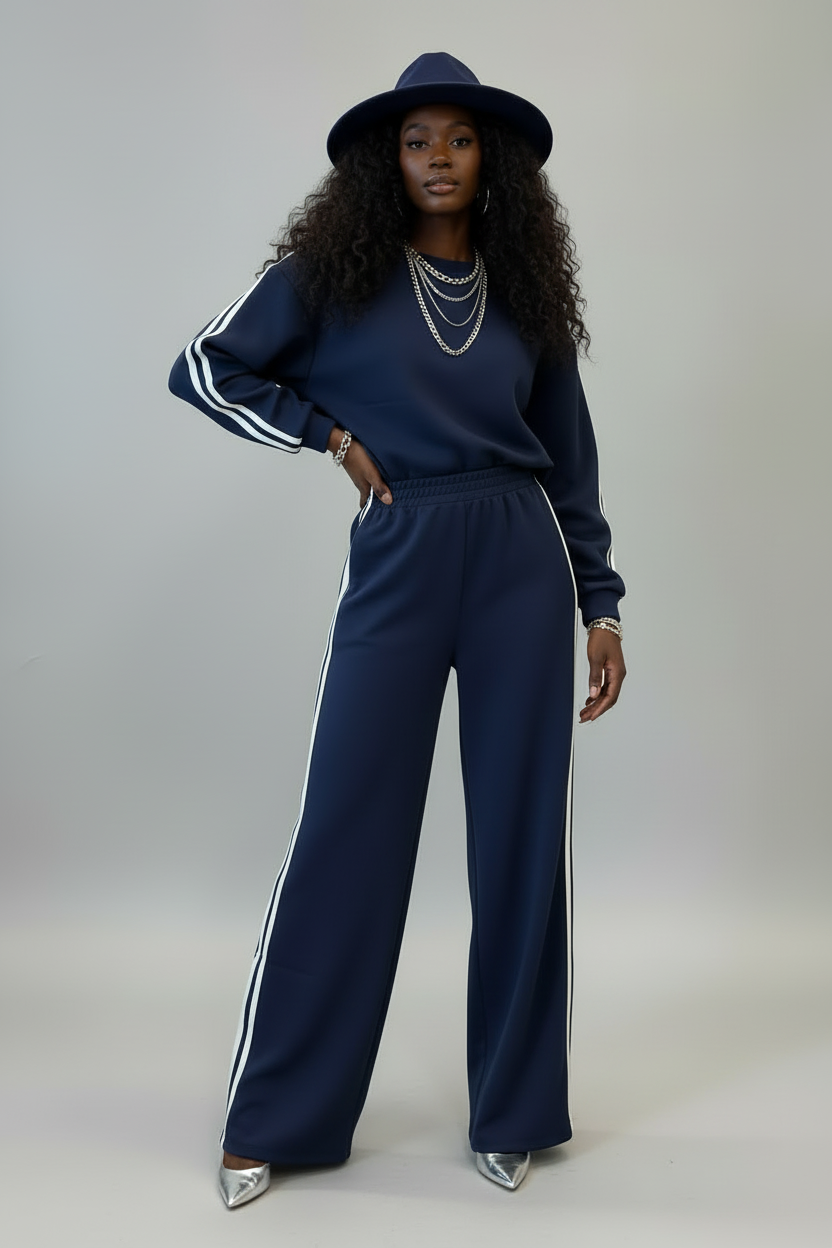 Woman wearing dirty blue varsity striped detail cropped pullover and wide leg pants outfit with hat and silver shoes
