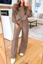 Woman wearing dark khaki polo collar V-neck pullover and drawstring sweatpants set with white sneakers indoors
