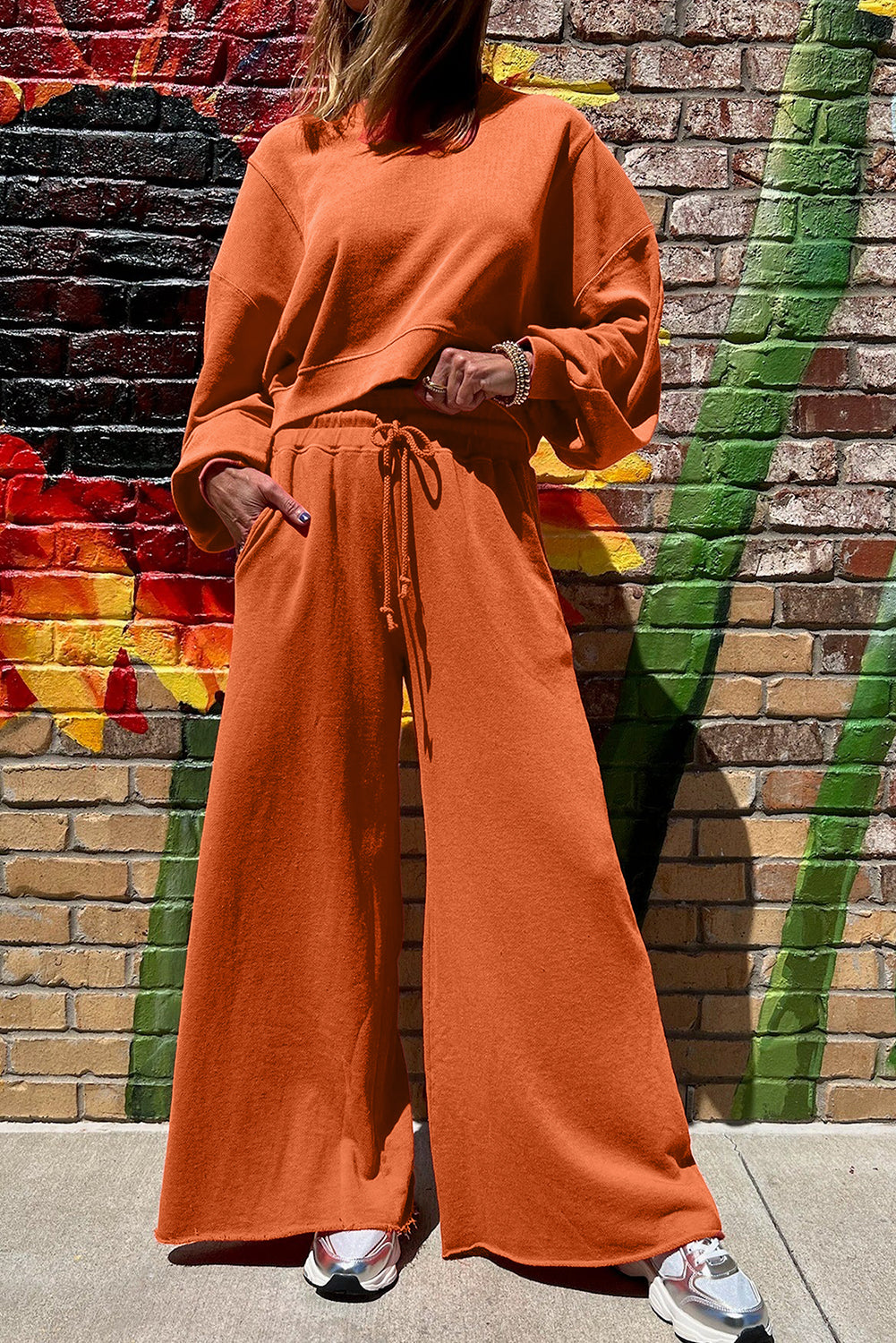 Flamingo drop shoulder crop pullover with drawstring wide leg pants set in orange, made of polyester and cotton blend.
