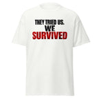 White unisex classic tee with "They Tried Us. We Survived" printed in bold black and red text